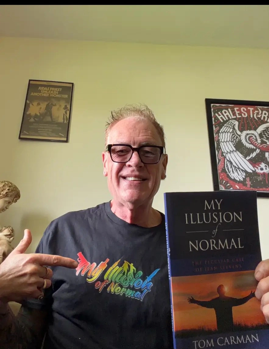 Tom Carman holding a copy of My Illusion of Normal